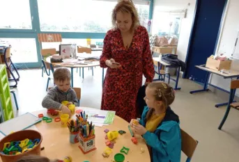deux élèves dans une salle de classe avec leur professeure