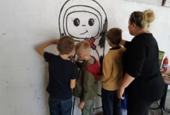 des enfants dessinent sur un mur