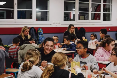 les élèves de l'internat partagent un repas avec une éducatrice.