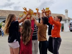 des enfants jouent avec des feuilles d'automne