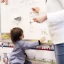 Une élève de maternelle est au tableau pour apprendre l'alphabet.
