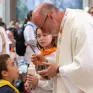 Un prêtre discute avec un jeune enfant pendant une messe. L'enfant porte un foulard jaune autour du cou.