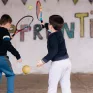 Deux élèves jouent au tennis dans une cour d'école.