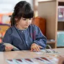 Une enfant de maternelle joue à un jeu de cartes